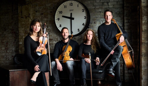 Four musicians pose with their instruments