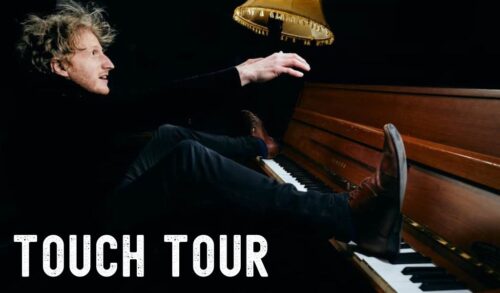 An image of a man sitting at a piano one foot on the keys Writing reads Touch Tour