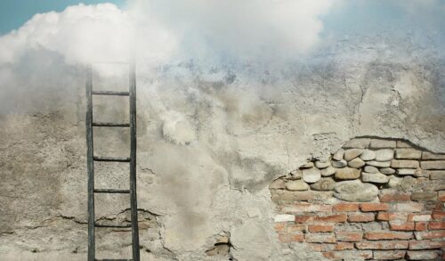 A ladder against a wall disappearing into the clouds