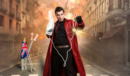 Ironing Board Man  a man in a long red leather coat holds an iron in the street theres fire behind him